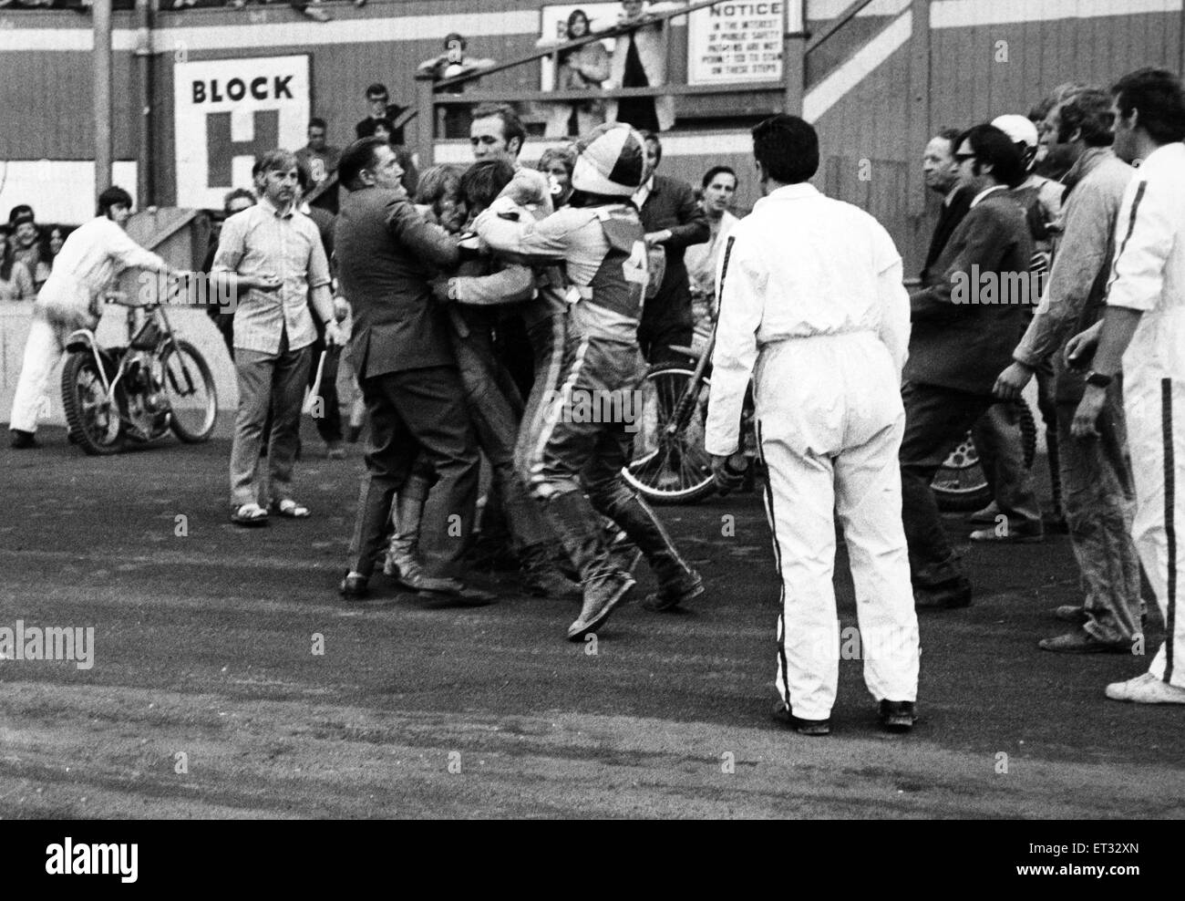 Im Belle Vue aufflammen. Beamten eilen Belle Vue Fahrer Alan Wilkinson und Leicesters Alan Cowland als die Fahrer kollidierte im Freien für alle während der Asse Spiel am Samstag zu trennen. 11. Juli 1971. Stockfoto