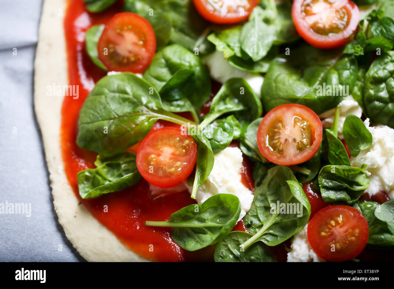 Traditionelle hausgemachte dünne Kruste Pizza mit Spinat, Tomaten und ...