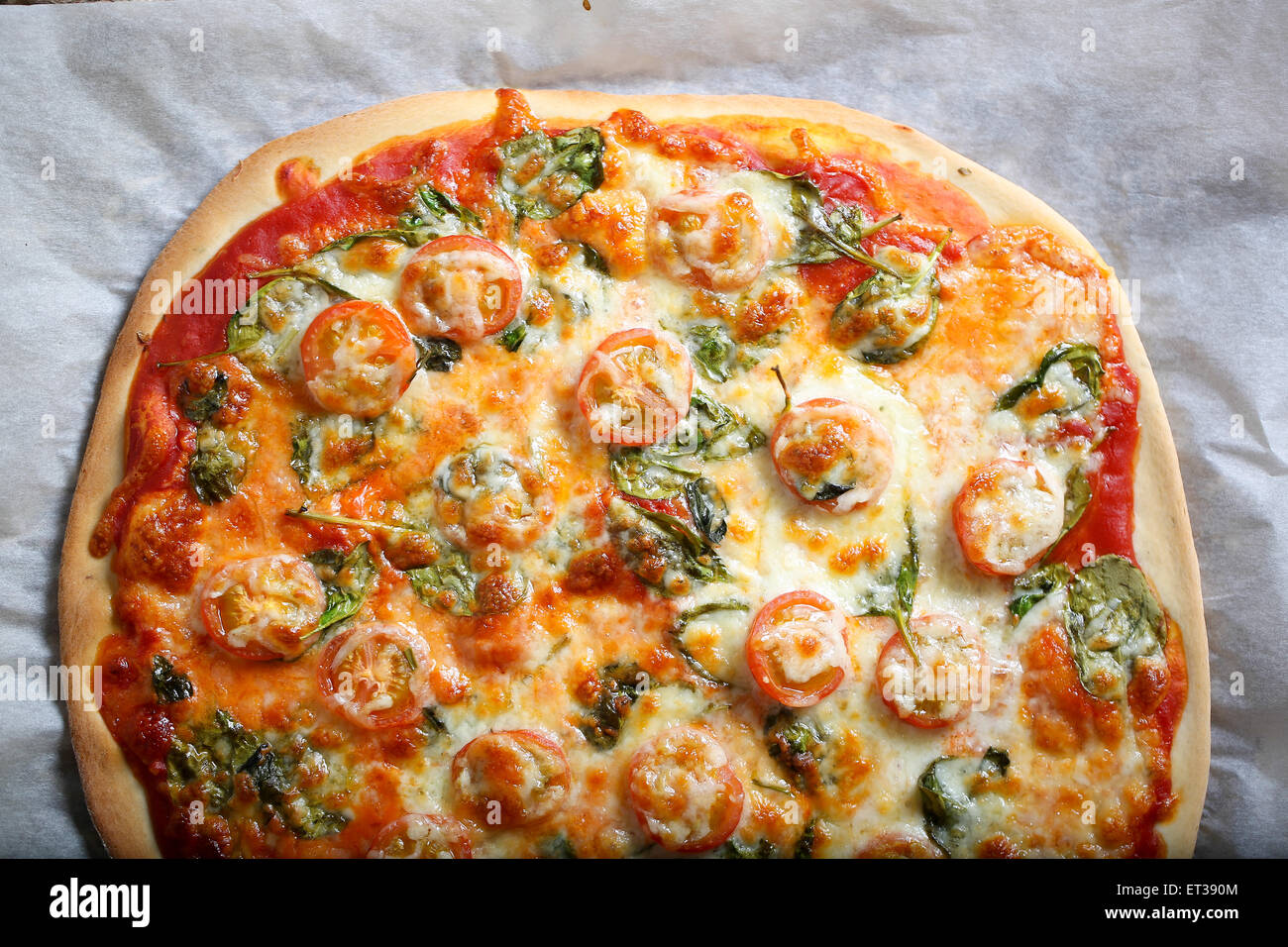 Traditionelle hausgemachte dünne Kruste Pizza mit Spinat, Tomaten und ...