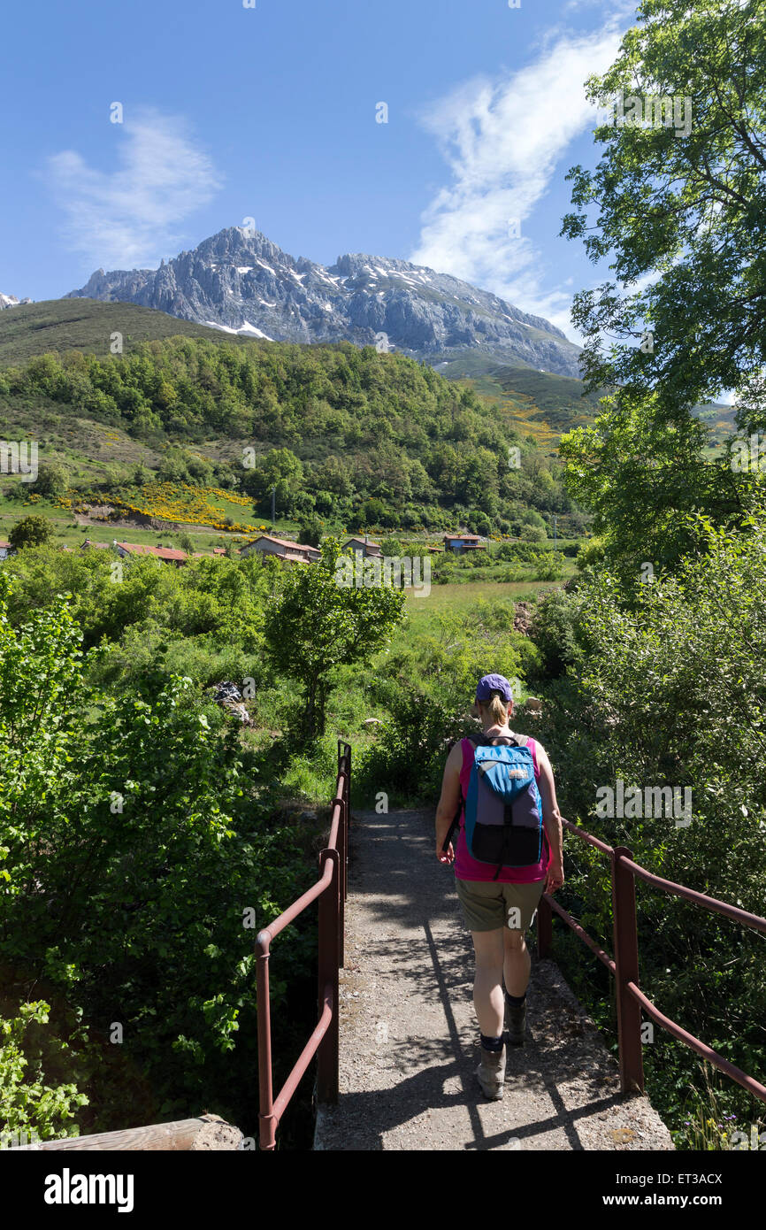 Walker in Richtung in Richtung the Dorf von Santa Marina de Valdeon mit den Bergen von Torre del Hoyo de Liordes und Torre de Salin Stockfoto