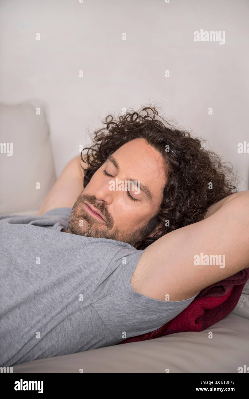 Mitte erwachsenen Mannes auf Schlafcouch, München, Bayern, Deutschland Stockfoto