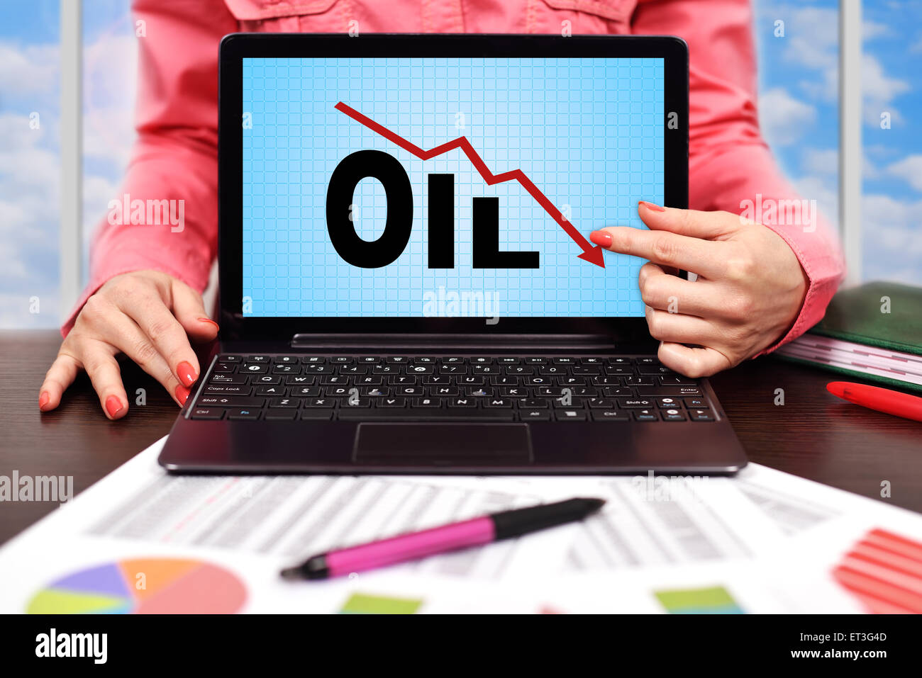 Geschäftsfrau, die auf Bildschirm Laptop mit sinkenden Öl-chart Stockfoto