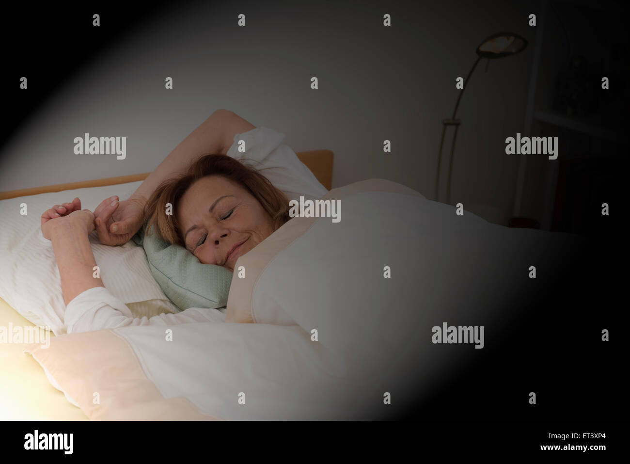 Ältere Frau schläft im Bett im Schlafzimmer, München, Bayern, Deutschland Stockfoto