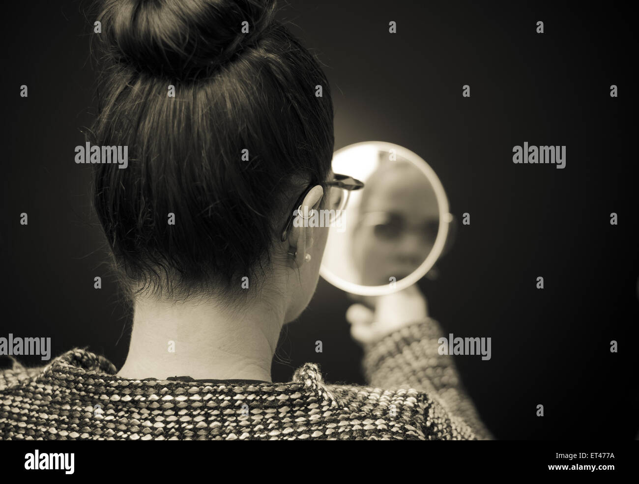 Geschäftsfrau, die Selbstreflexion im Spiegel zu betrachten Stockfoto