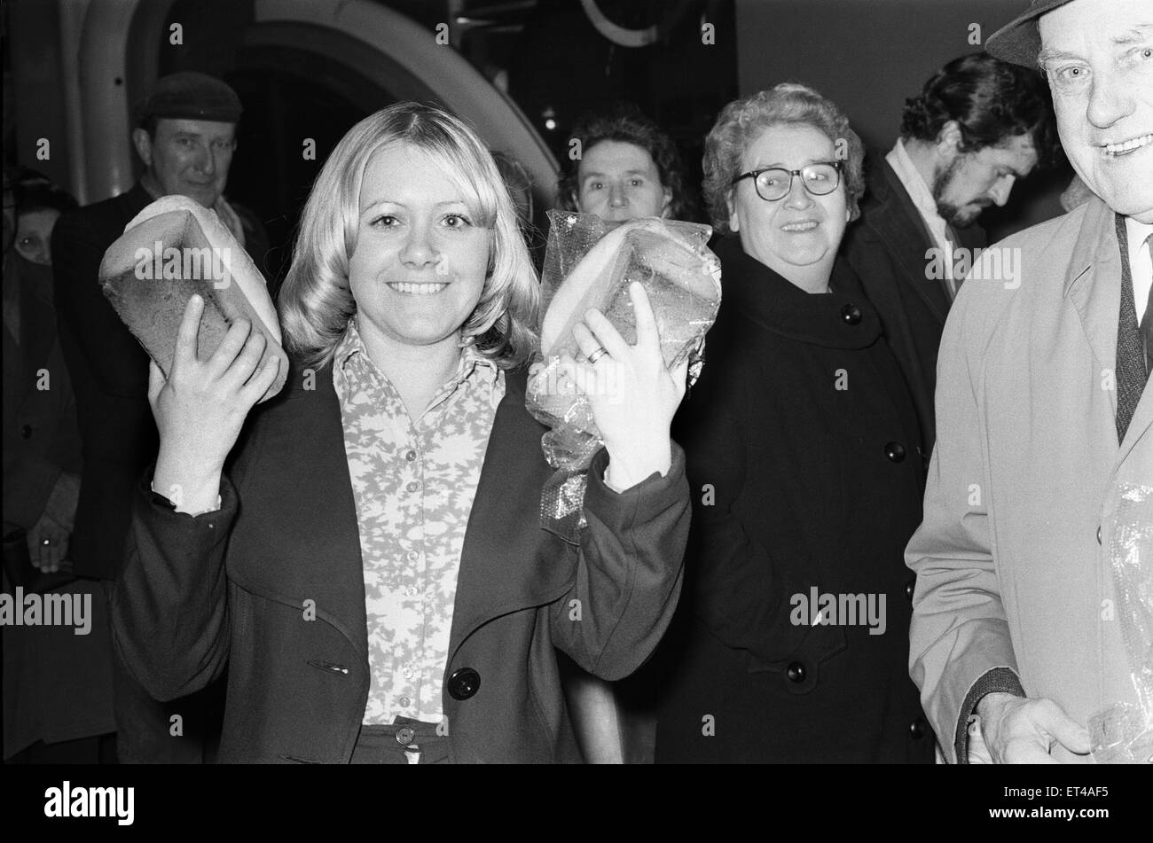 DIE siebziger Jahre waren eine Zeit des Streiks, und im Dezember 1974, die großen nationalen Bäcker beschlossen, nachziehen, fordern eine 66 % Lohnerhöhung. Mitarbeiter von größeren Firmen hatte leere Regale und Dutzende von Kunden abwenden. Kleine Bäckereien waren Arbeiten aus dem Ruder aber nicht in der Lage, die Nachfrage als Geschäfte rief in für zusätzliche Lieferungen. Als Hausfrauen beschlossen, ihr eigenes Brot backen, stiegen die Verkaufszahlen der Hefe. (Bild) Zufriedener Kunde zeigt ihr zwei Brote Brot. 3. Dezember 1974 Stockfoto