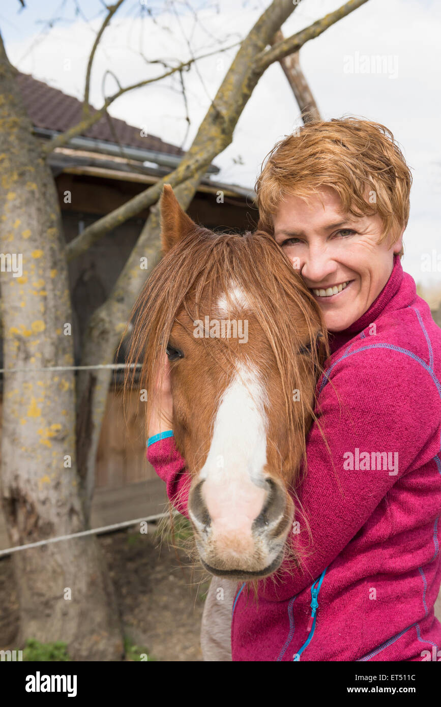 Frau umarmt Pferd in stabilen Bayern Deutschland Stockfoto