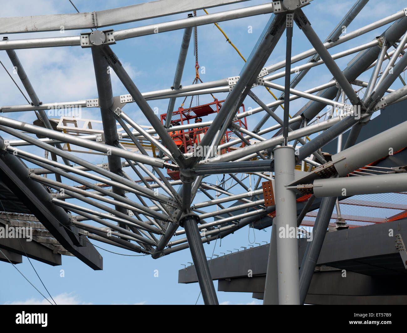 Handwerker in einer Halterung über dem neuen Dach der Etihad Stadium, South Expansion Projekt ausgesetzt, Manchester, England, Großbritannien Stockfoto