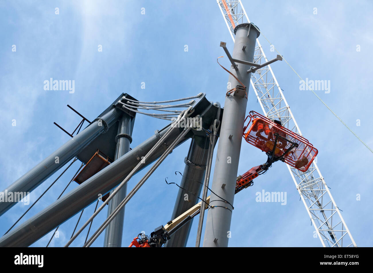 Arbeiter in einer Access-Plattform installieren Krawatte Seile zur Unterstützung der neuen Dach, Etihad Stadium Südtribüne, Manchester, England, UK Stockfoto