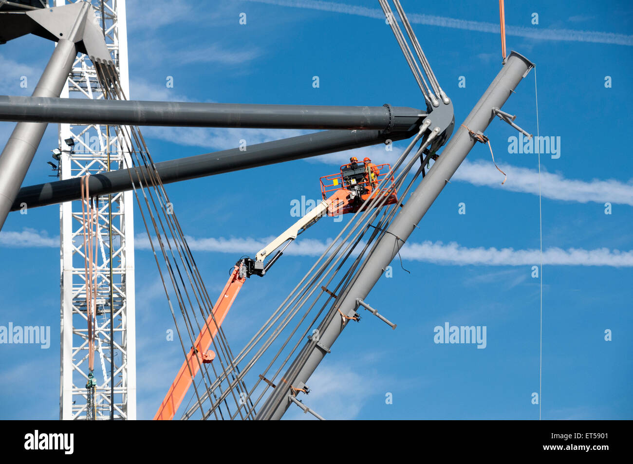 Arbeiter in einer Access-Plattform installieren Krawatte Seile zur Unterstützung der neuen Dach, Etihad Stadium Südtribüne, Manchester, England, UK Stockfoto