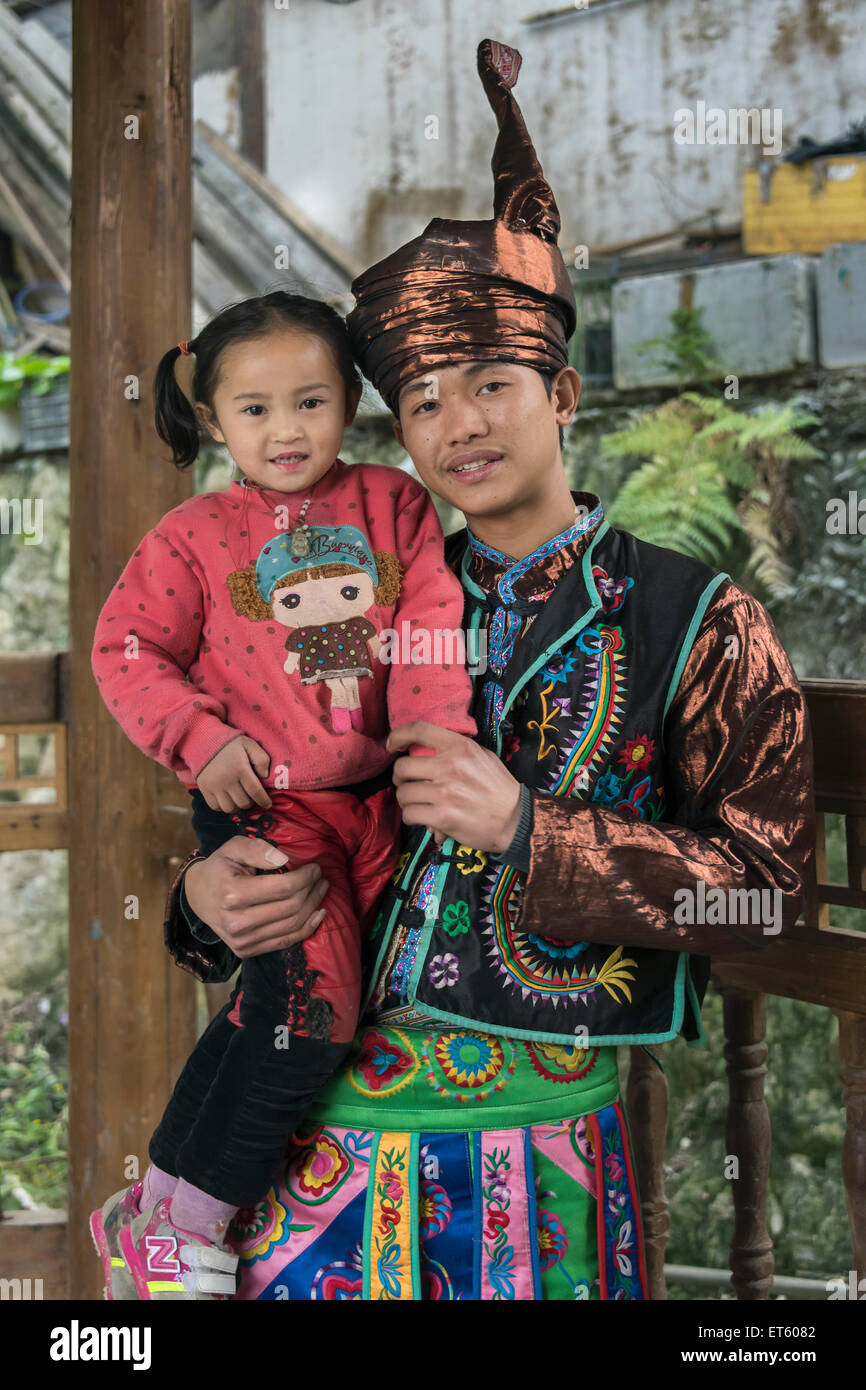 Dong-Mann in ethnische Kleidung hält sein kleines Mädchen, Zhaoxing Dong Dorf, Guizhou Provinz, China Stockfoto