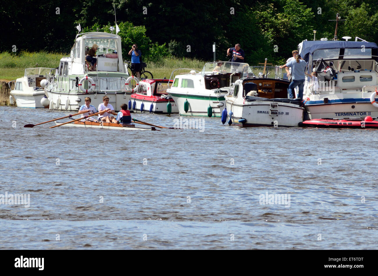 Gleichen paar Rudern Besatzung Reihe vorbei Vergnügen Boote, die an den Ufern der Themse im Windsor vor Anker liegen. Stockfoto