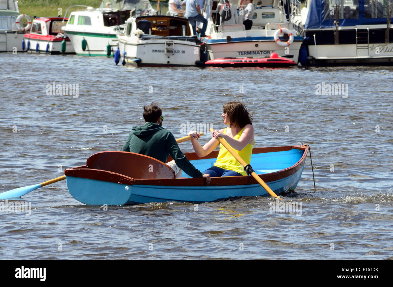 Ein paar viel Spaß in einem Ruderboot auf der Themse, während im Hintergrund, Menschen genießen ihre Cruiser. Stockfoto