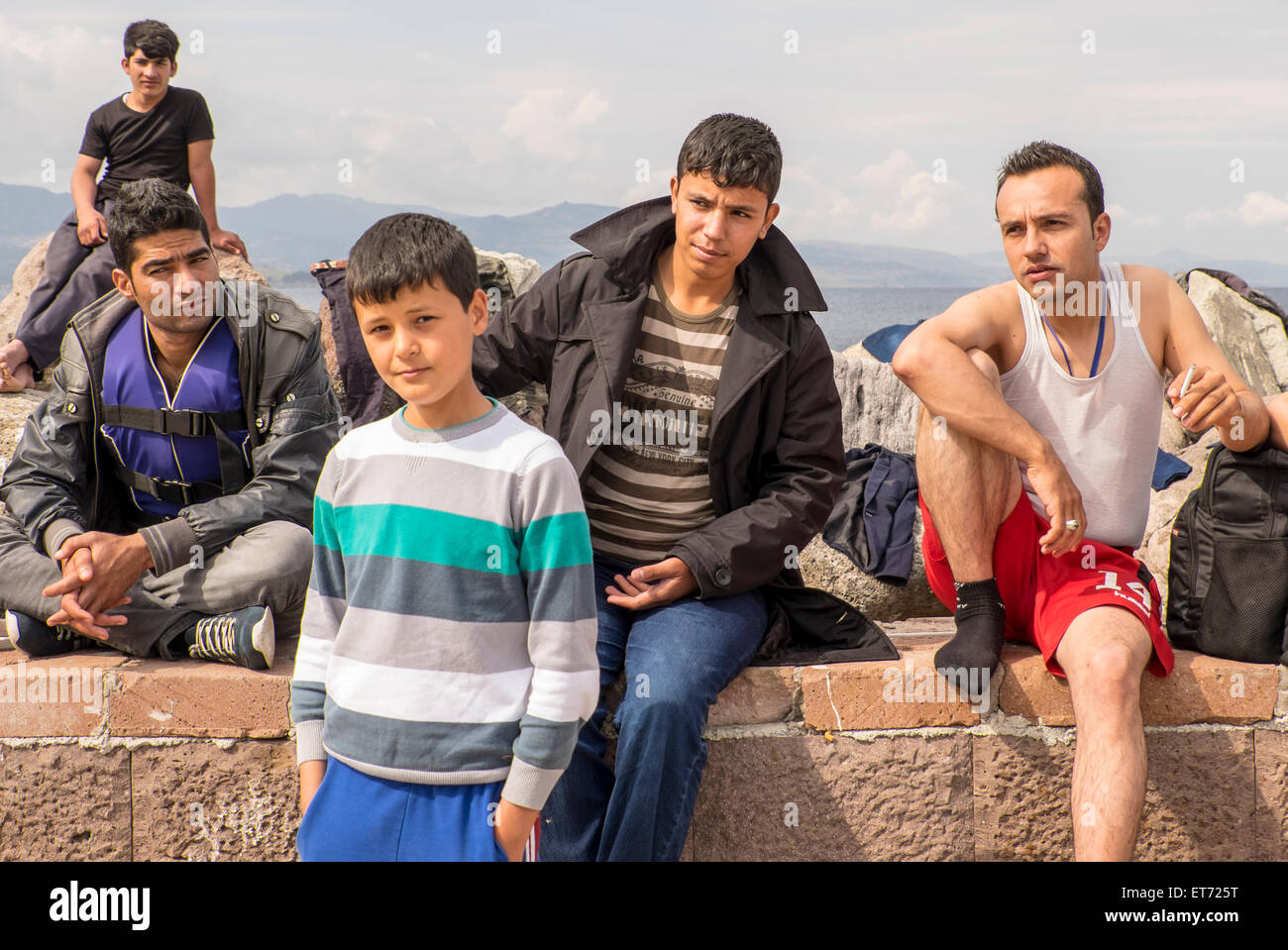 Fünf syrische Flüchtlinge abtrocknen im Hafen von Molyvos nach der Kreuzung aus der Türkei nach Griechenland in Schlauchbooten. Stockfoto