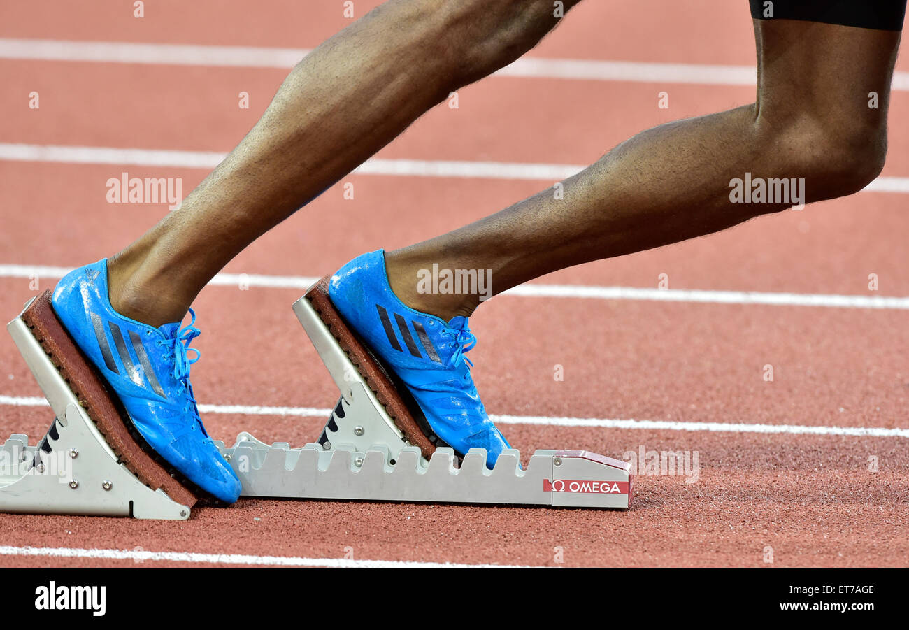 Ein männlicher Athlet (Afrikaner) ist immer bereit auf dem Startblock auf einer Leichtathletikbahn Rennen kurz vor dem Start Stockfoto