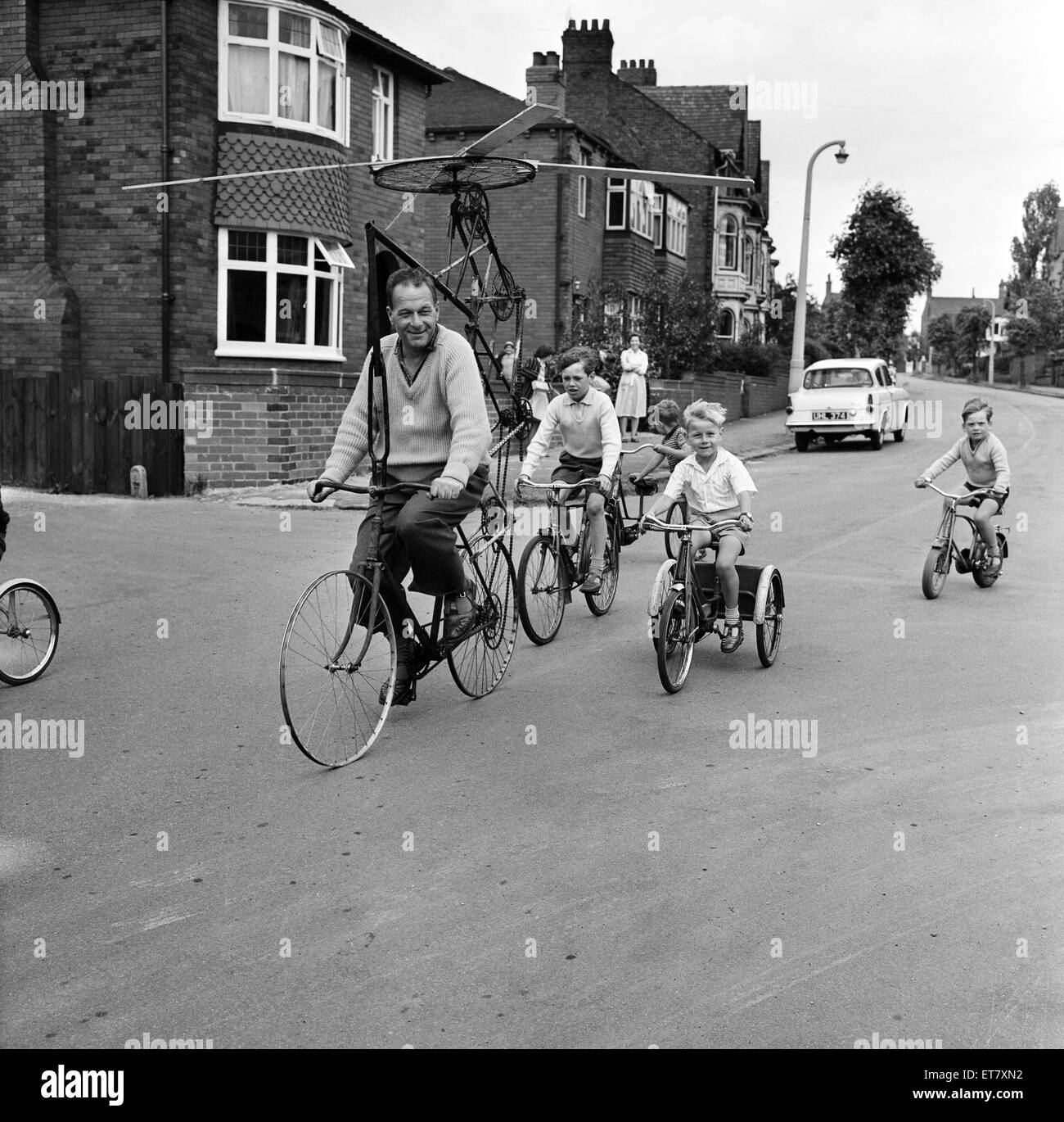 Herr Clifford Davis von Leeds Road Wakefield, versucht, seine Flugmaschine von Bits des alten Pedal Zyklen gemacht. Nach ihm auf der Straße auf ihren Bikes sind Nachbarn Kinder, West Yorkshire, 25. Juni 1965. Stockfoto