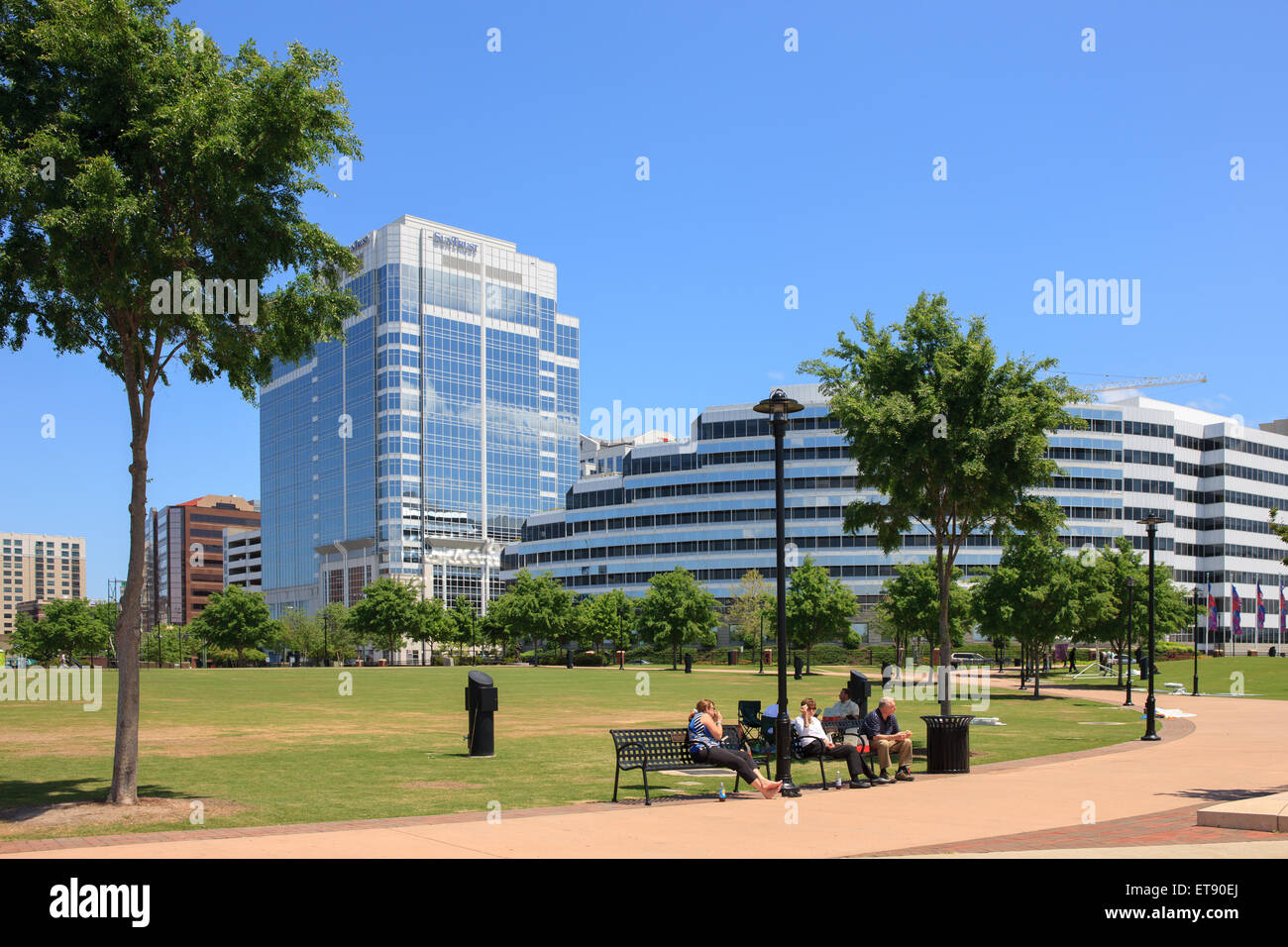 Menschen essen ihr Mittagessen auf einer Bank im Stadtpark Punkt in der Innenstadt von Norfolk, Virginia. Stockfoto