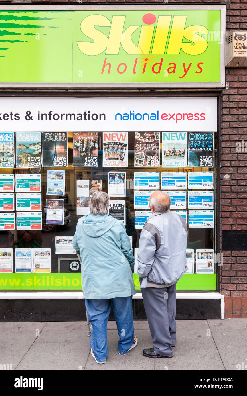 Ältere Menschen, die im Urlaub Informationen im Fenster "ein Reisebüro, Fähigkeiten Urlaub, Nottingham, England, Großbritannien Stockfoto
