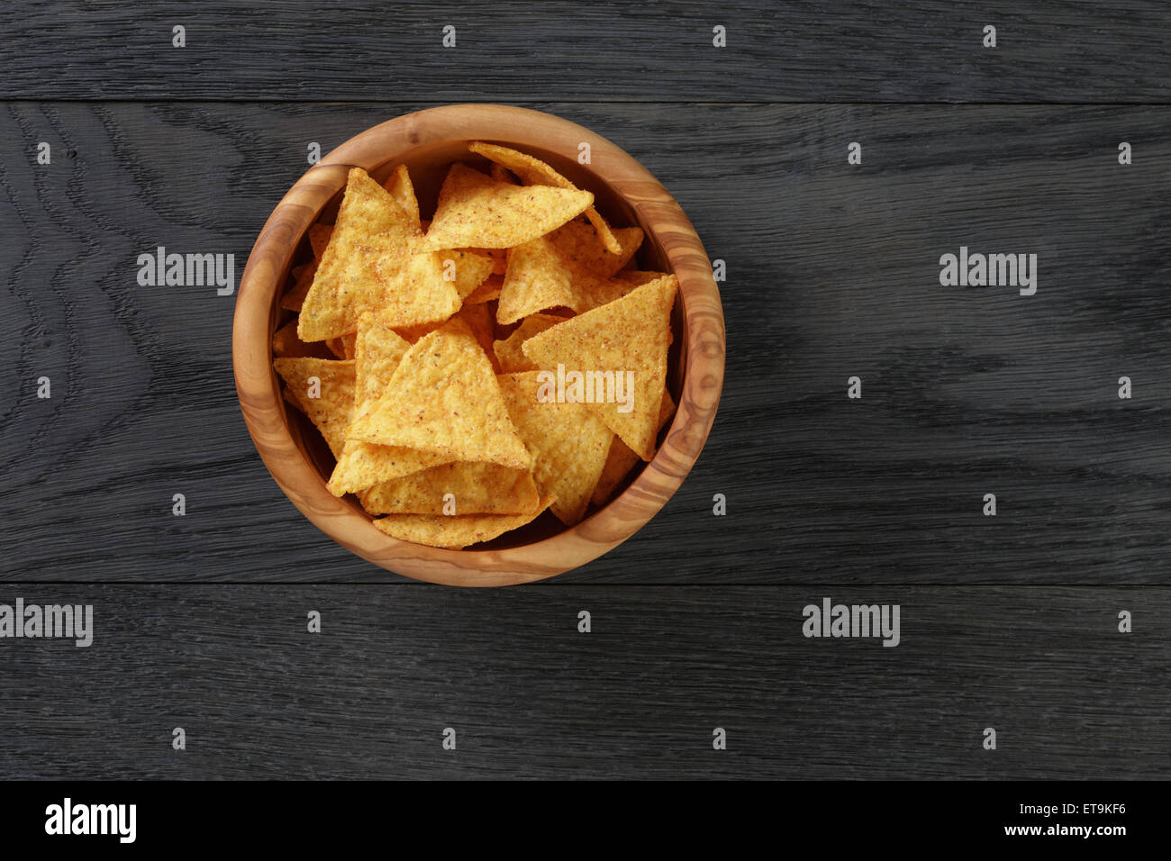 Tortilla-chips in Oliven Holz Schüssel auf Holztisch Stockfoto