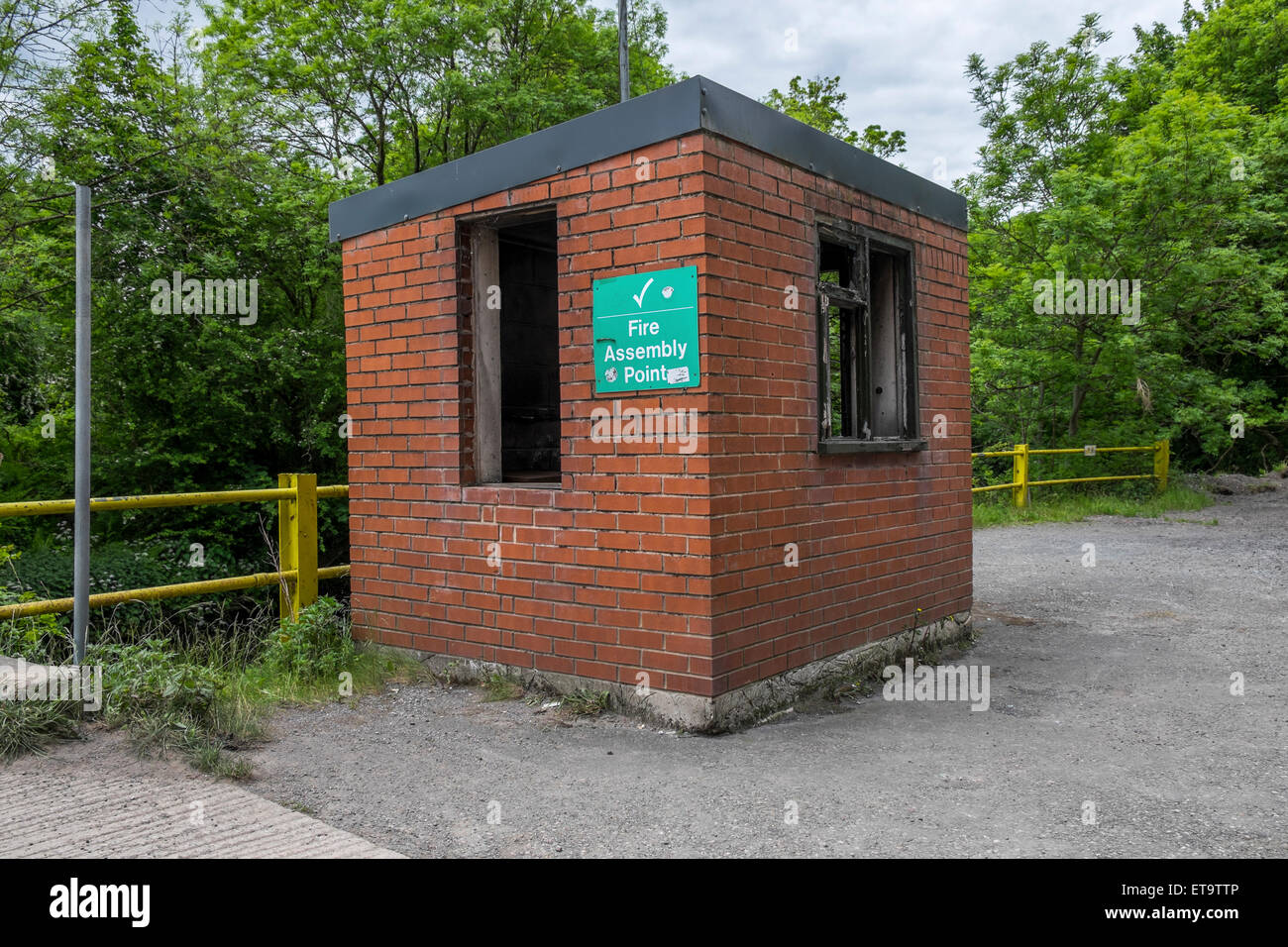 Zerbrochenes Fenster in einem verlassenen Sicherheitsbüro außerhalb einer verlassenen und stillgelegten Fabrik Stockfoto