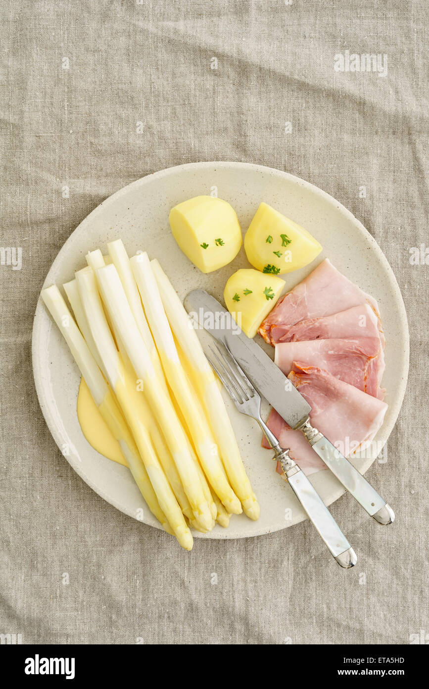 Weißer Spargel mit Kartoffeln, gekochten Schinken und Sauce Hollandaise Stockfoto