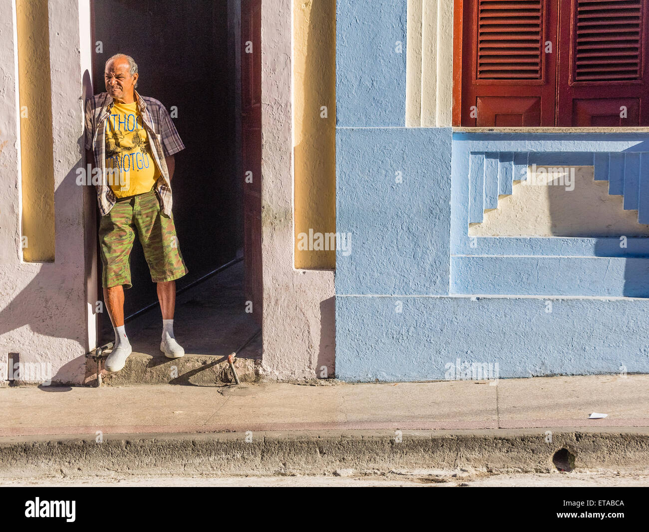 Hispanic Mann stand in den frühen Morgenstunden Licht in Tür öffnen in der Innenstadt von Santiago De Cuba. Stockfoto