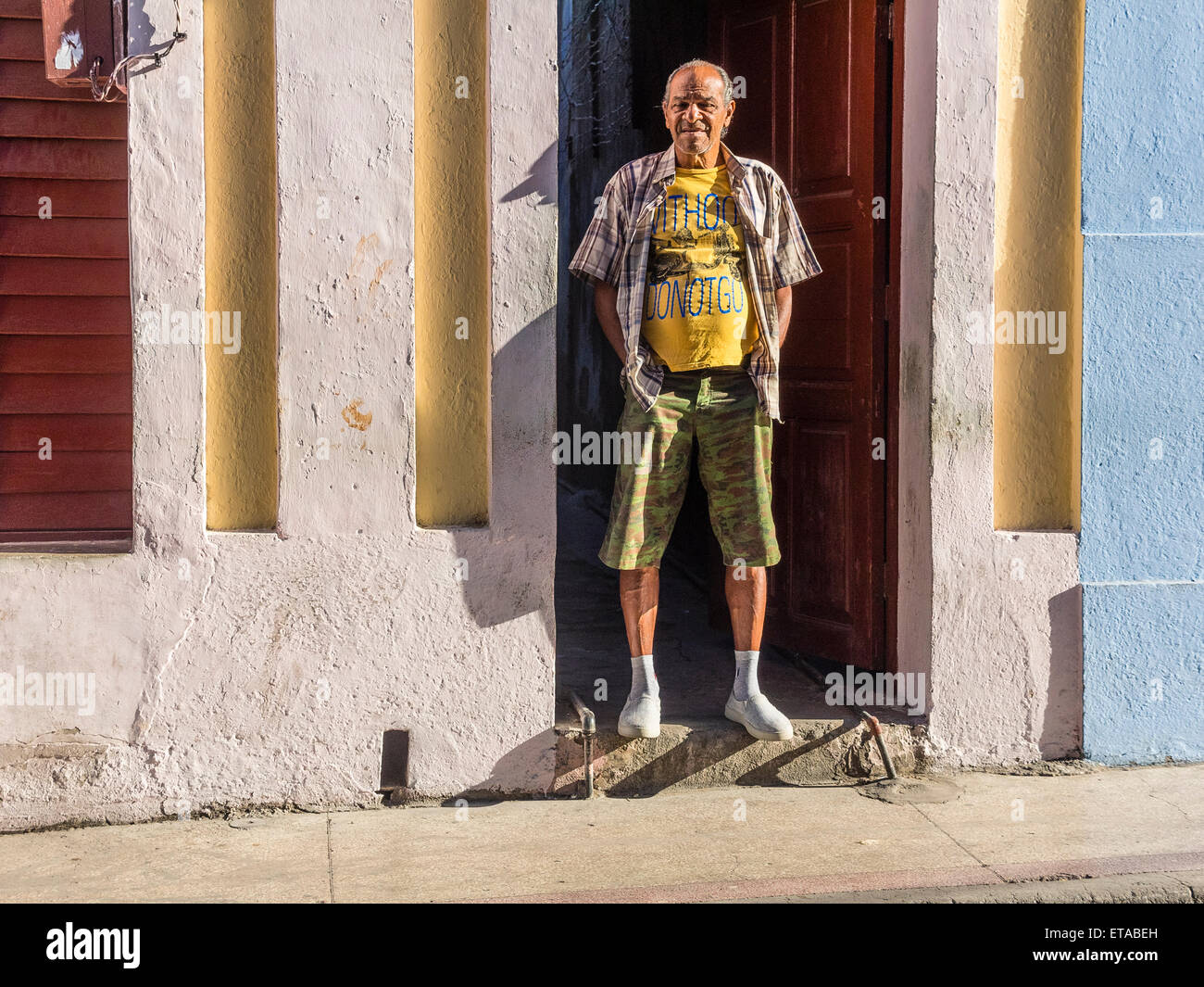 Hispanic Mann stand in den frühen Morgenstunden Licht in Tür öffnen in der Innenstadt von Santiago De Cuba. Stockfoto