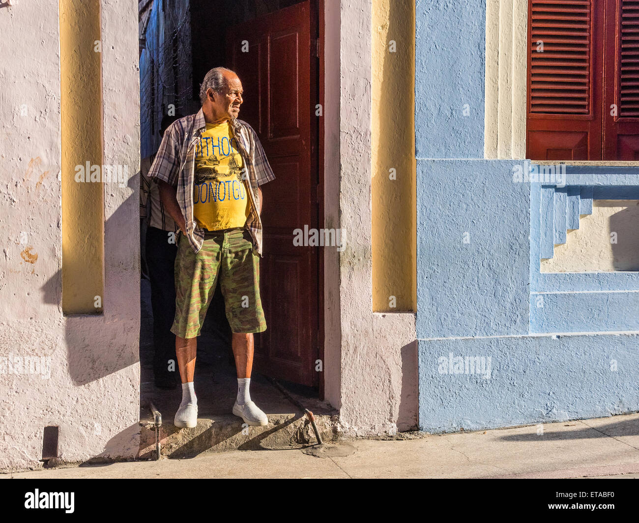 Hispanic Mann stand in den frühen Morgenstunden Licht in Tür öffnen in der Innenstadt von Santiago De Cuba. Stockfoto