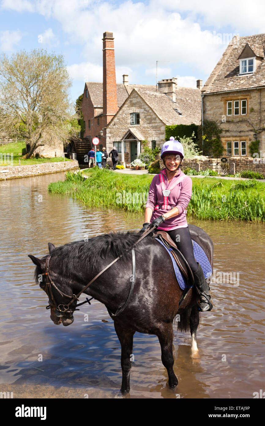 Gießen das Pferd in den Augen der Fluss fließt durch die Cotswold Dorf von Lower Slaughter, Gloucestershire UK Stockfoto