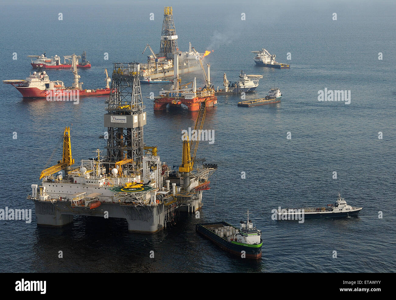 Die mobilen Offshore-Bohreinheit Development Driller II bereitet eine Erleichterung bei der BP Deepwater Horizon Öl bohren Ölpest Katastrophe vor Ort 18. Mai 2010 im Golf von Mexiko. Entdecken Sie Enterprise weiterhin das Bohrschiff erfassen Öl und Gase aus den geplatzten Aufsteiger im Hintergrund verbrennen. Stockfoto