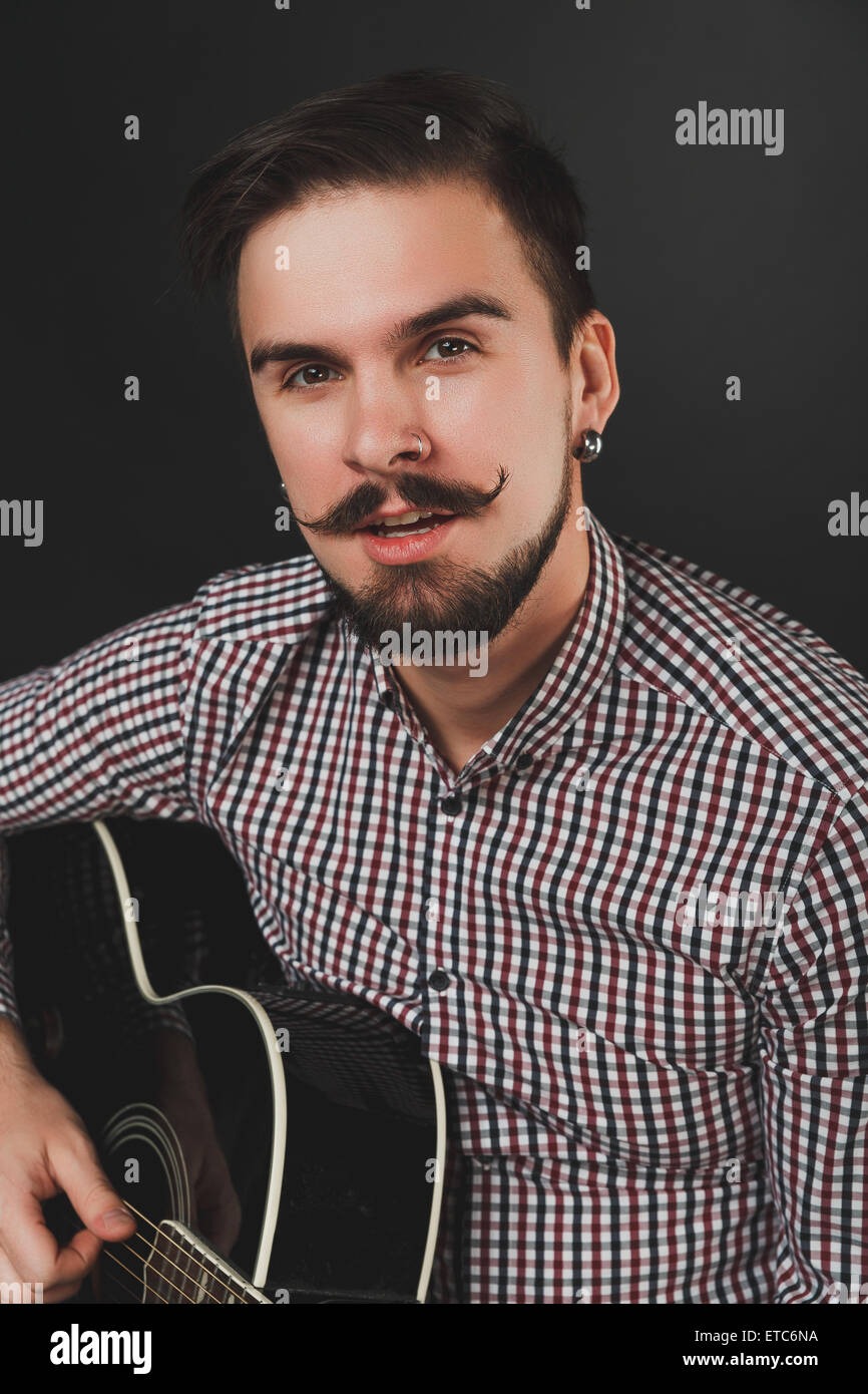 gut aussehend Mann mit Bart hält Akustikgitarre Stockfoto