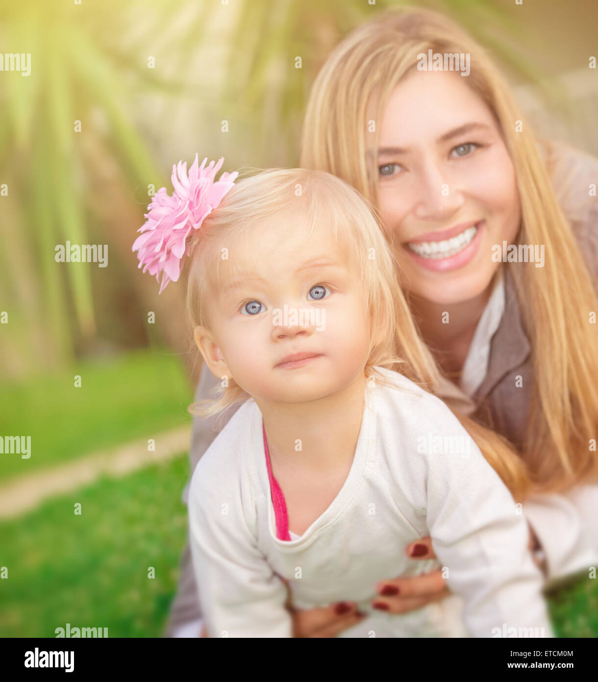 Mutter mit Tochter spielen im Freien, liegend auf frischen grünen Wiese im Park, glückliche Familie Sommer Urlaub Stockfoto