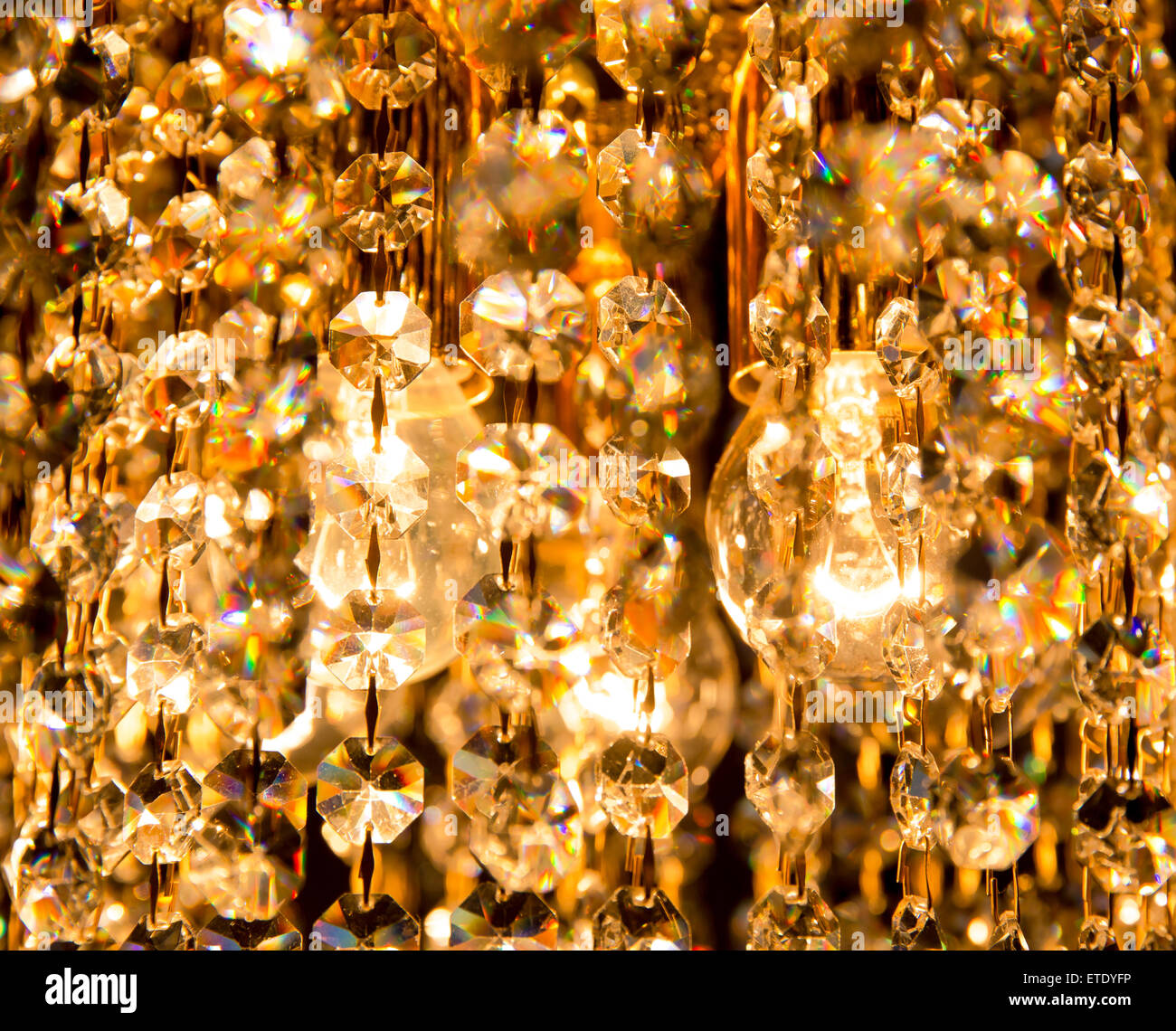 erstellt von Kristall-Kronleuchter, der mit goldenem Licht glänzt Hintergrund Stockfoto