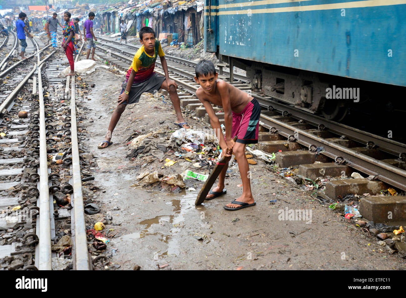 Dhaka, Bangladesch. 13. Juni 2015. Slumkinder sind Cricket auf die Bahngleise, umgeben von provisorischen Häusern in Dhaka, Bangladesch Zwirnen. Am 13. Juni 2015 In Bangladesch die lebhafte Hauptstadt Dhaka ist der Platz begrenzt. Tausende von provisorischen Häusern sind jede Woche in Slum-Gebieten, einige davon direkt neben die Gleise zu bauen. Diese Geschichte handelt von ihnen, jene Menschen riskant leben neben diesem Bahnhof Spuren. Bildnachweis: Mamunur Rashid/Alamy Live-Nachrichten Stockfoto