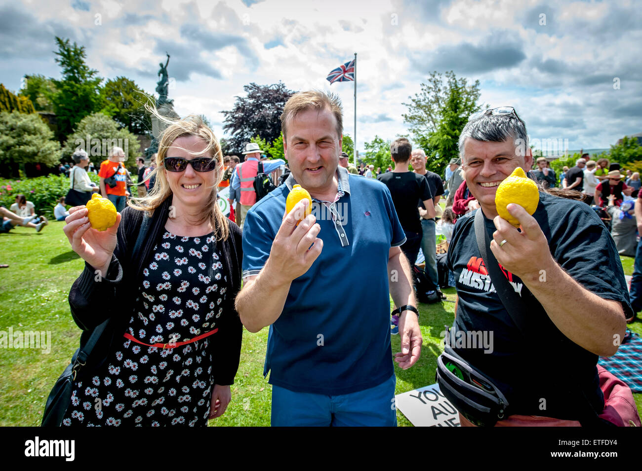 Exeter, Devon, UK. 13. Juni 2015. Crowd-Mitglieder halten die Sybolic Zitrone während der Devon "Ende Sparmaßnahmen jetzt!" Rallye organisiert in Northernhay Gärten, Exeter auf June13th, 2015 in Exeter, UK Credit: Clive Chilvers/Alamy Live News Stockfoto