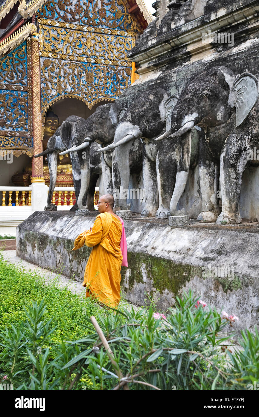 Ein Mönch in der Nähe der Stupa im Wat Chiang Man in Chiang Mai. Es heißt auch Wat Chiang Mun. Stockfoto