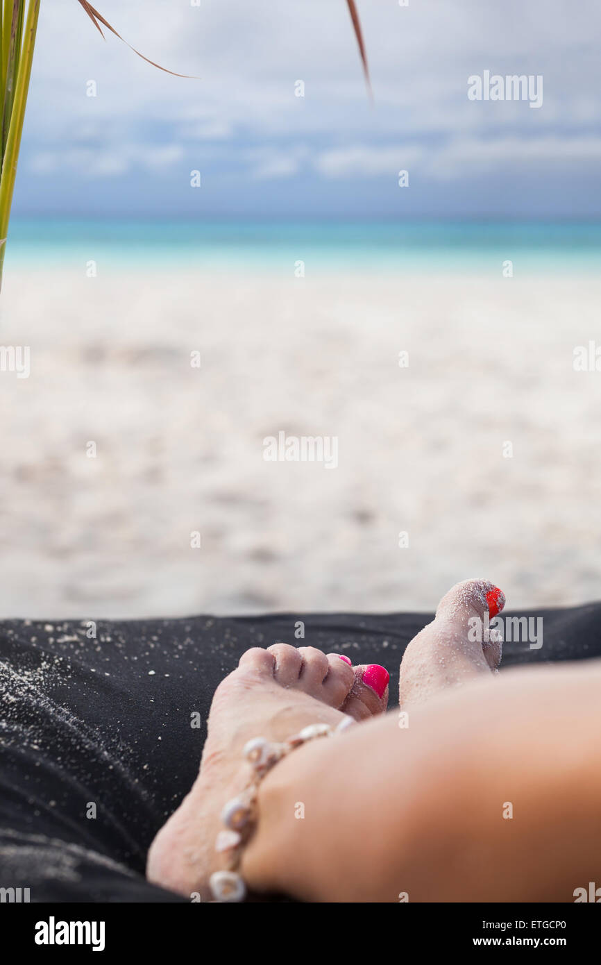 Weibliche Beine entspannen am Strand mit Blick aufs Meer Hintergrund Reisen Reiseziel Konzept Stockfoto