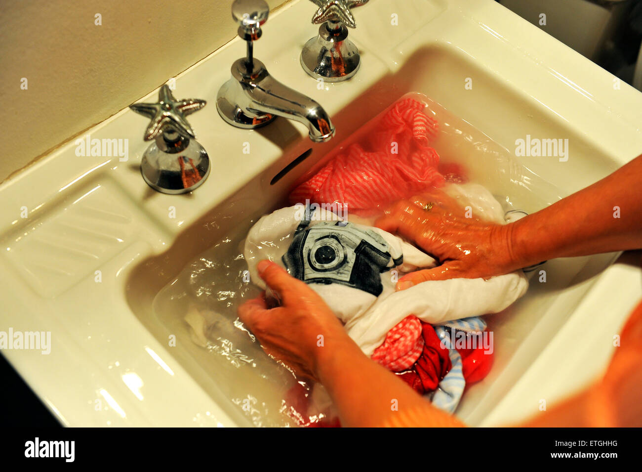 Waschen von Hand in die Vintage Waschbecken des Badezimmers ein T-shirt mit einer Kamera drauf drucken England UK Europe Stockfoto