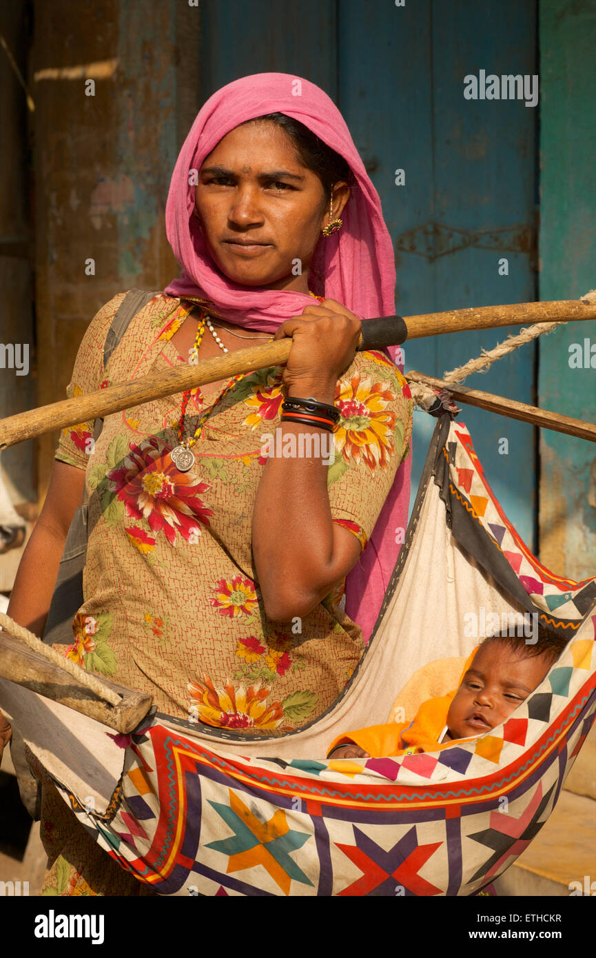 Rajasthani-Frau mit ihrem Baby im Tragetuch. Jaisalmer, Rajasthan, Indien Stockfoto