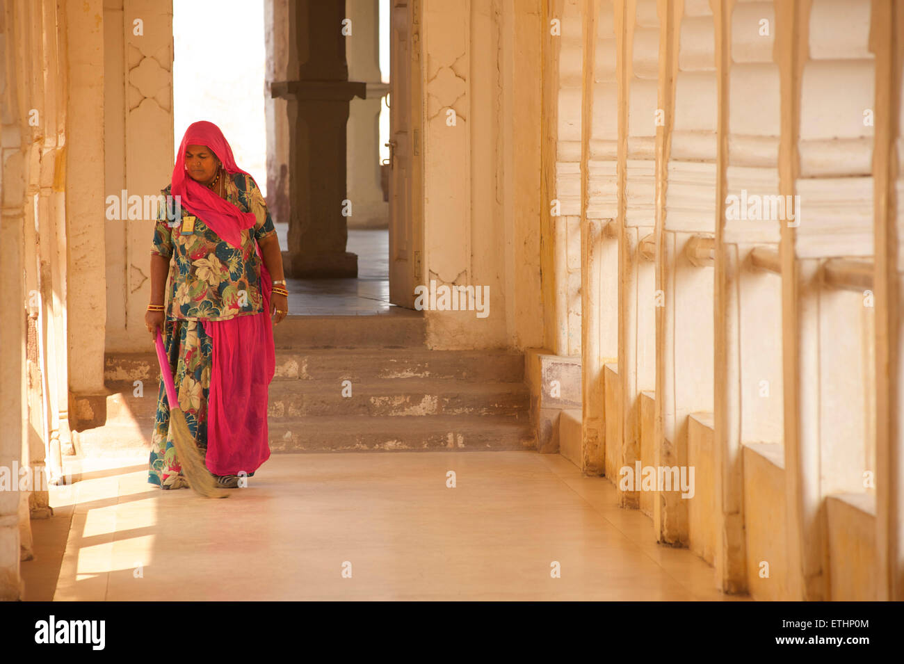Indische Frau fegt Korridor an Mehrangarh Fort, Jodhpur, Rajasthan, Indien Stockfoto