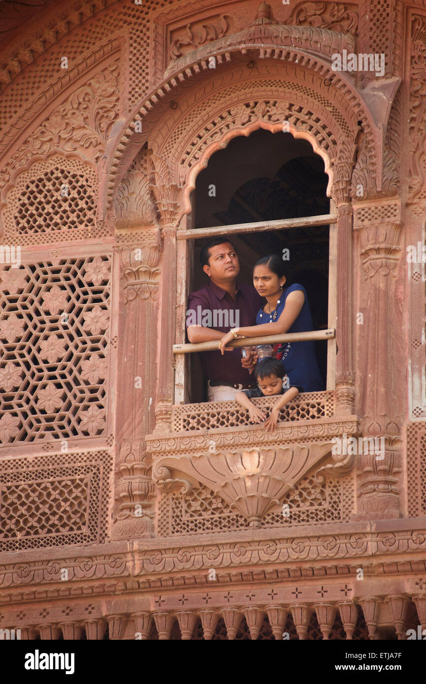 Indische Familie mit Blick vom Fenster in geschnitzten Fassade an Mehrangarh Fort, Jodhpur, Rajasthan, Indien Stockfoto