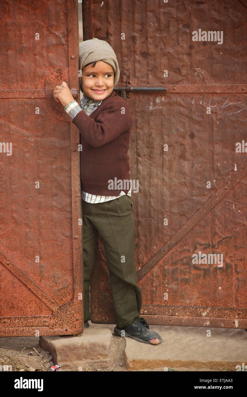 Indischer Junge mit Loch im Schuh an Tür. Jodhpur, Rajasthan, Indien Stockfoto