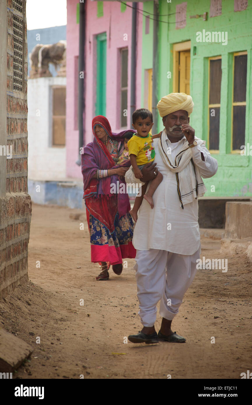 Indischer Mann und Frau mit Kindern zu Fuß hinunter eine Dorfstraße außerhalb Jodhpur, Rajasthan, Indien Stockfoto