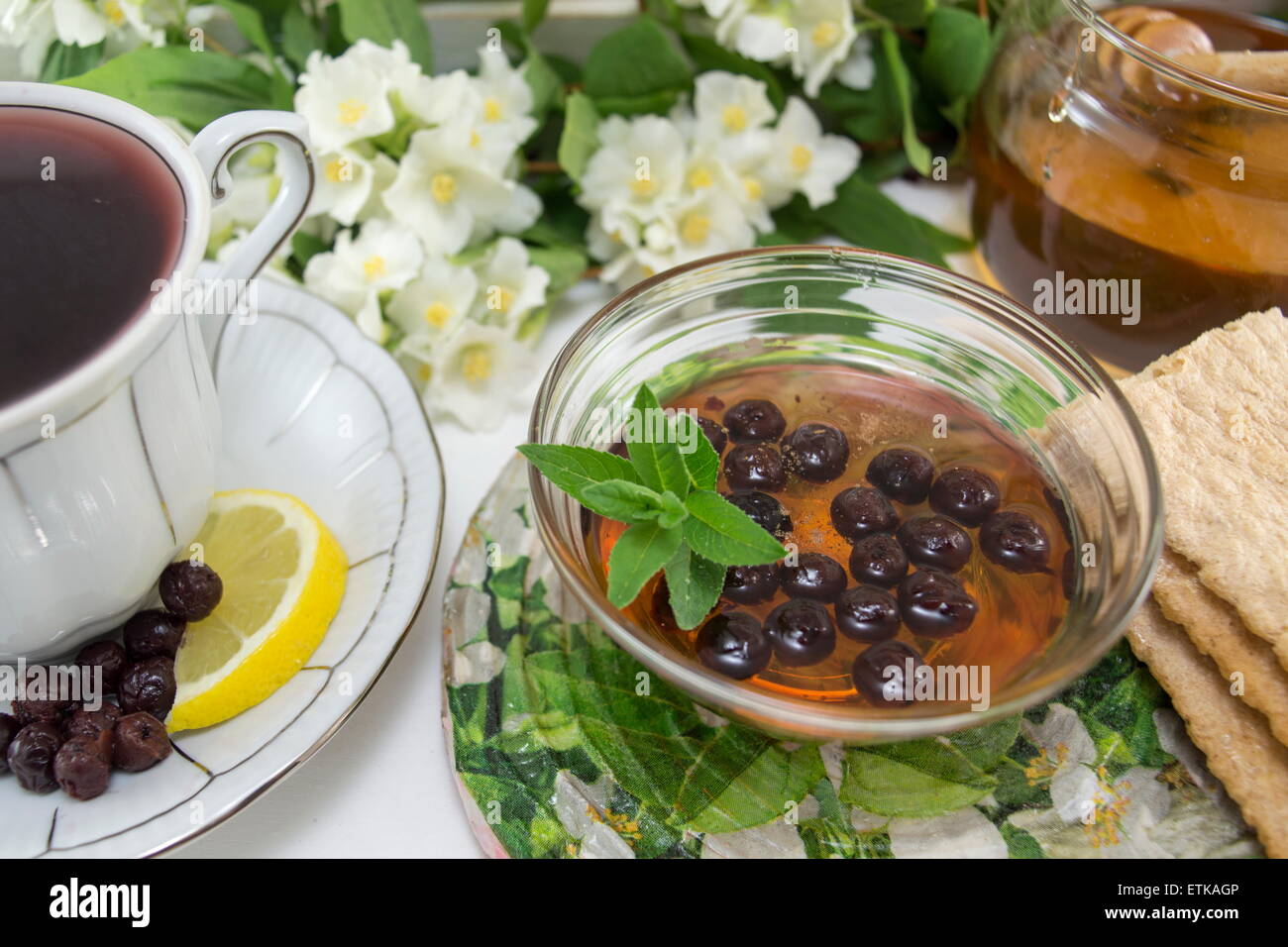 Aronia Tee in einer Porzellantasse auf einer Blume verziert Tisch Stockfoto