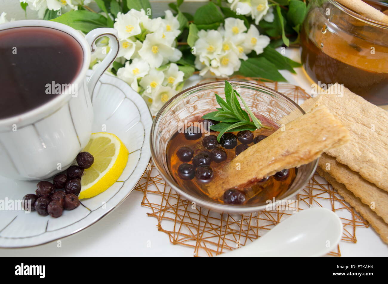 Aronia Tee in einer Porzellantasse auf einer Blume verziert Tisch Stockfoto