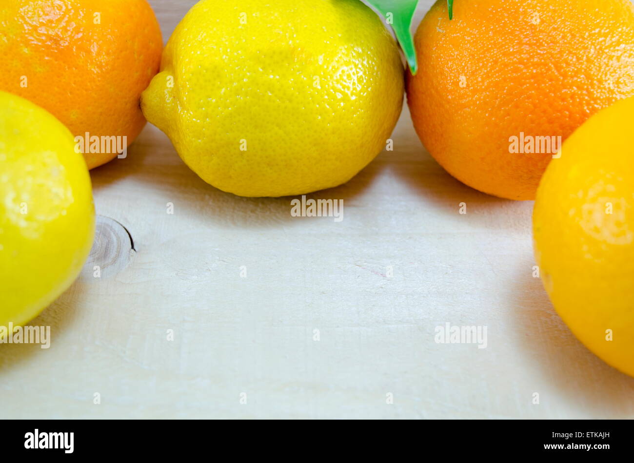 Ganze Zitronen und Orangen in einem Kreis mit textfreiraum in der Mitte Stockfoto