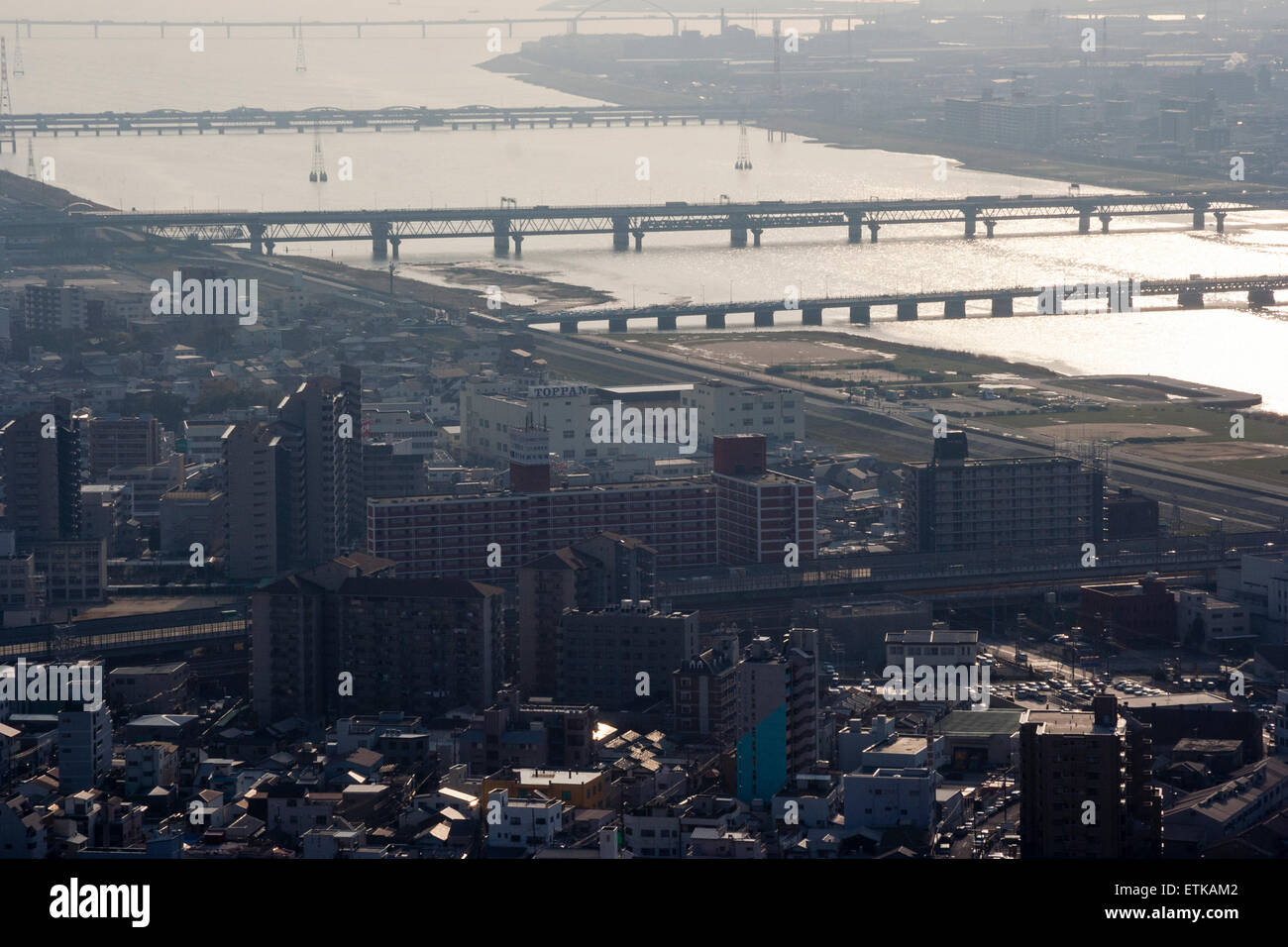 Luftbild vom Umeda Sky Building, Osaka, von Eisenbahn- und Straßenbrücken, die Kyu-Yodo, Yodo, Fluss, bei Sonnenuntergang, goldene Stunde überspannen. Hazy aufgrund von Umweltverschmutzung. Stockfoto