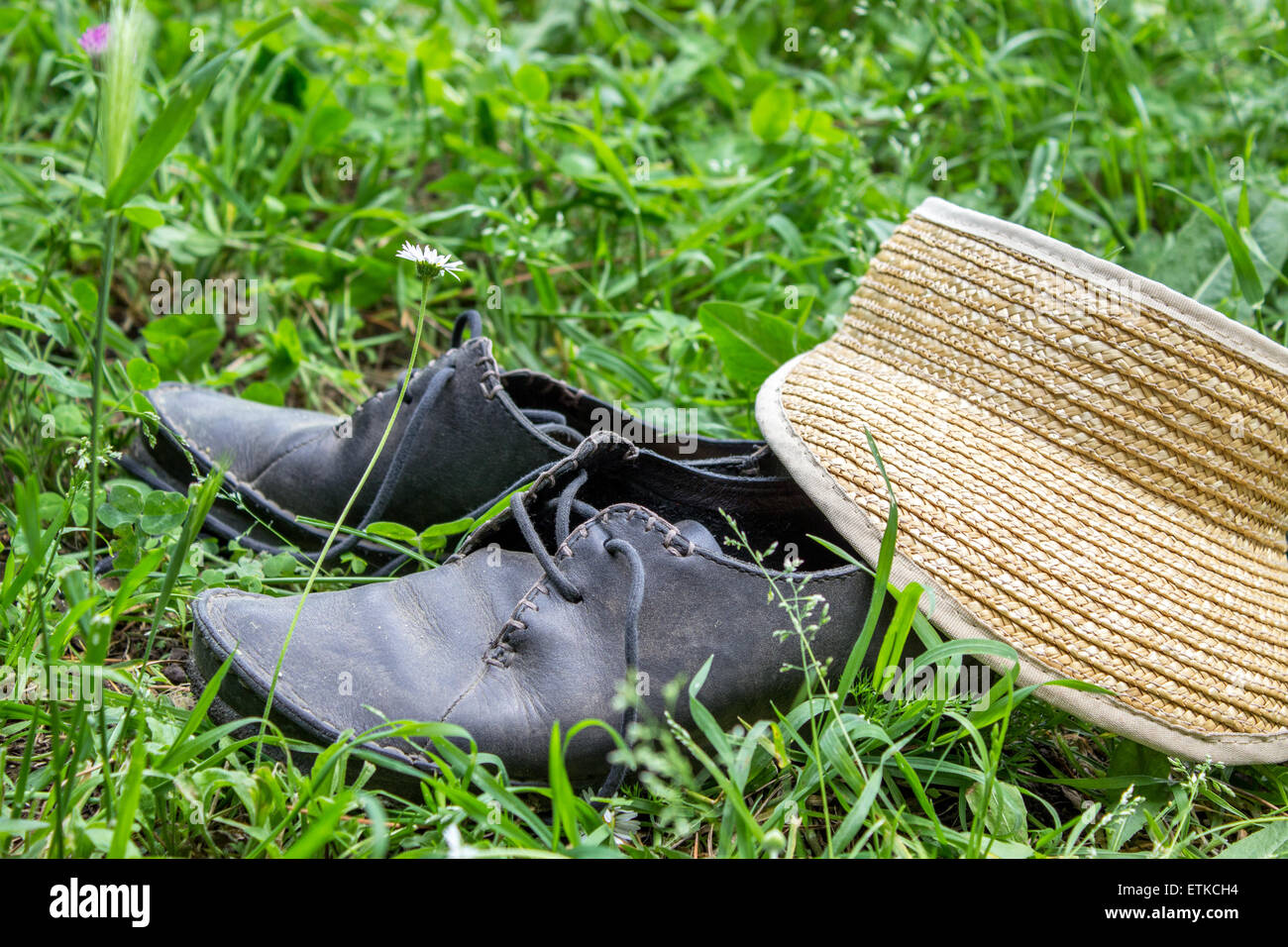 Kappe und staubig, schwarze Schuhe in der Wiese Stockfoto