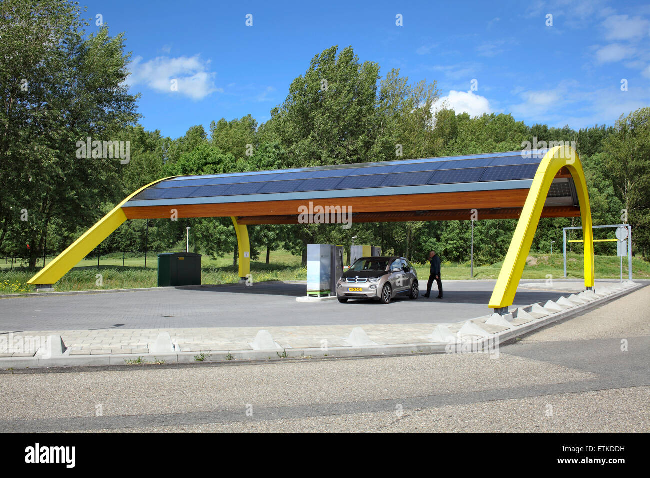 Ein Elektroauto aufgeladen an einem Fastned Elektrofahrzeug Ladestation an einer Autobahnraststätte in den Niederlanden. Stockfoto