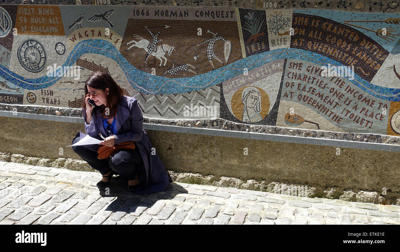 Junge Frau Handy hockend von Mosaik Thames Walk London UK Stockfoto