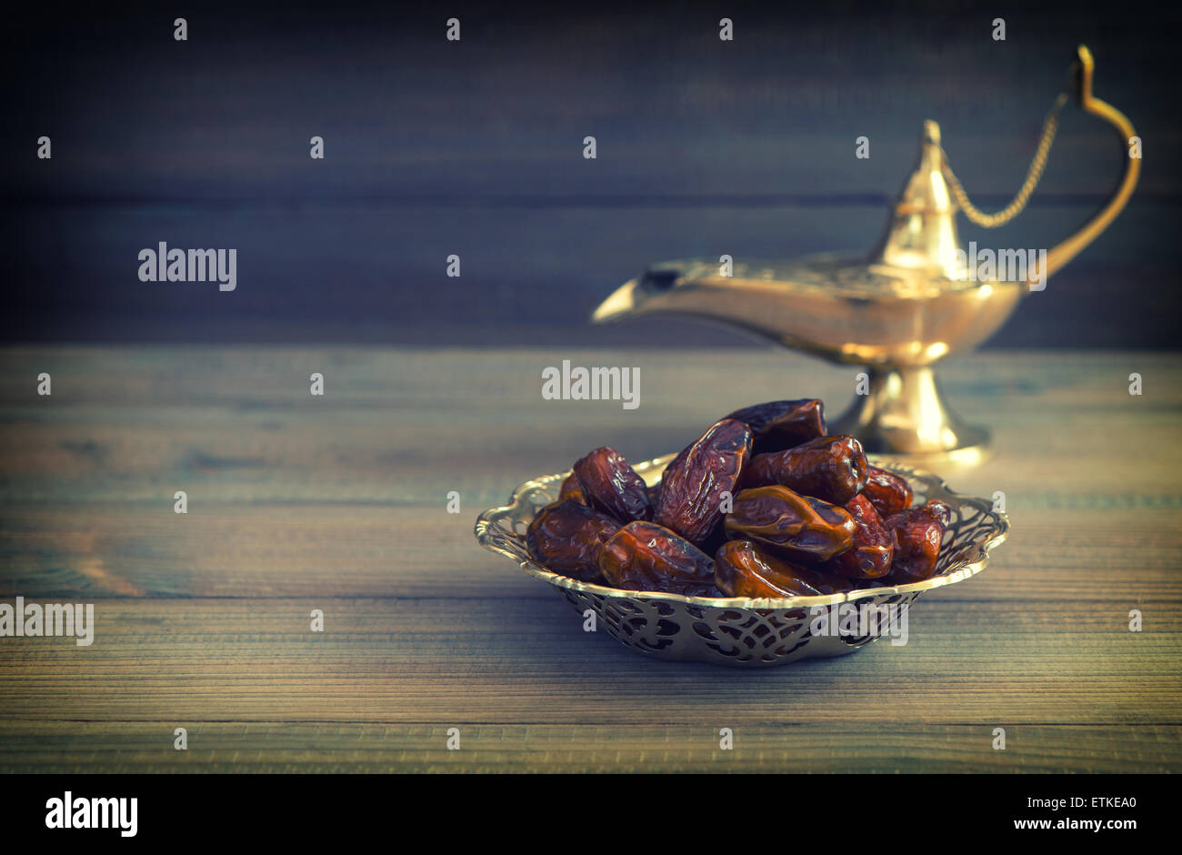 Termine in goldene Schale und arabischen Aladdin Lampe auf hölzernen Hintergrund. Vintage-Stil getönten Bild Stockfoto